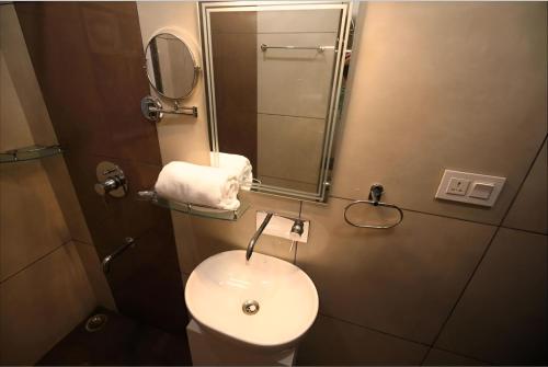 a small bathroom with a toilet and a mirror at Sumitel Premier Inn in Siliguri