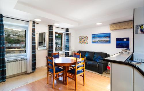 a living room with a table and chairs and a couch at Three-Bedroom Apartment In Povlja in Povlja
