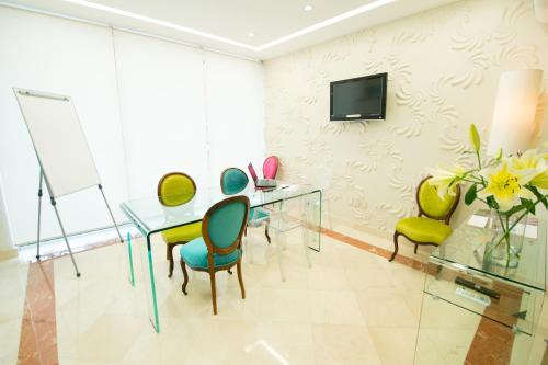 a dining room with a glass table and chairs at Grand Hotel Tepatitlán in Tepatitlán de Morelos