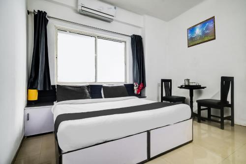 a bedroom with a large bed and a window at Super Hotel O Indraprasth in Indore