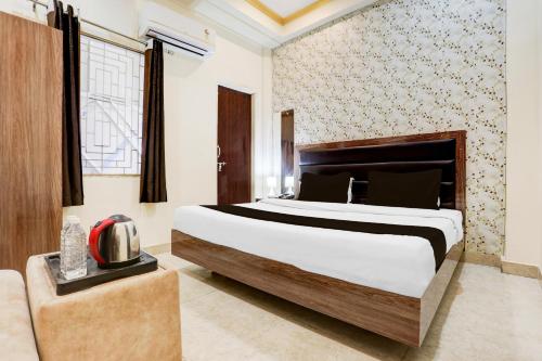 a bedroom with a large bed and a couch at Super OYO Hotel O Sankat Mochan Gandhi Nagar in Kakarmatha