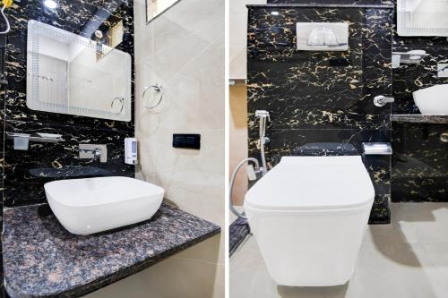 a bathroom with a white toilet and a black wall at Super Townhouse Oak Ratanpur Panki in Kānpur