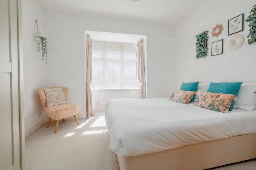 a white bedroom with a bed and a chair at Beaufort Heights by Grandeur Property in Iford