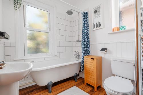 a bathroom with a tub and a sink and a toilet at Beaufort Heights by Grandeur Property in Iford