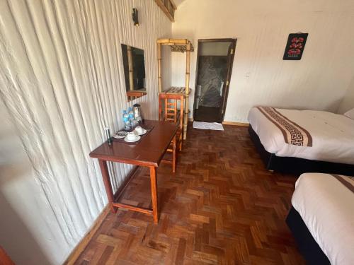 a room with two beds and a table in a room at Ambokili Cottages in Kimana
