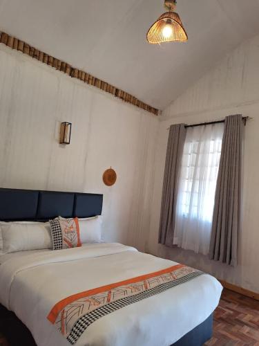 a bedroom with a large bed and a window at Ambokili Cottages in Kimana