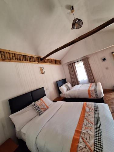 a bedroom with two beds in a room at Ambokili Cottages in Kimana