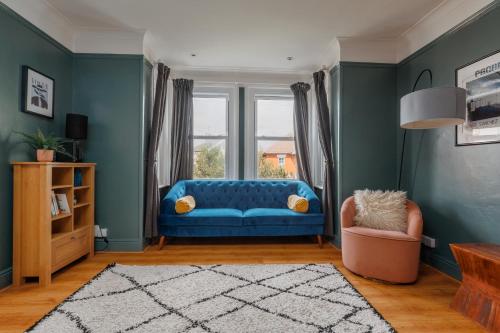 a living room with a blue couch and a window at Beaufort Heights by Grandeur Property in Iford