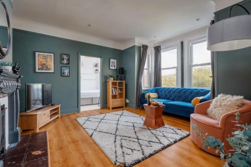 a living room with a blue couch and a tv at Beaufort Heights by Grandeur Property in Iford