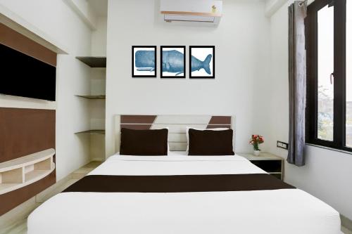 a bedroom with a large white bed and two windows at Super Townhouse Khatu Shyam Formerly Hotel Dev Bhumi in Khātu