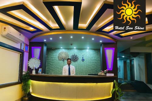 a man standing at a bar in a restaurant at Hotel Sun Shine in Cossimbāzār