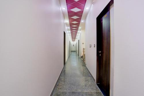 a corridor with white walls and a purple ceiling at Super Townhouse Khatu Shyam Formerly Hotel Dev Bhumi in Khātu