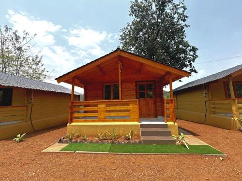 Cabaña de madera con porche y escaleras delante en DEER COTTAGES Agonda, en Agonda
