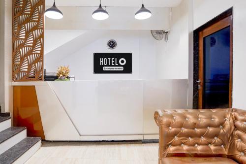 a leather chair in a lobby with a hotel sign on the wall at Super Hotel O Itwari Railway Station Formerly Hotel Prime in Nagpur