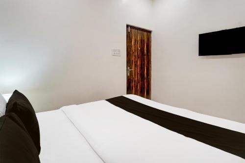 a bedroom with a white bed and a television at Super Hotel O Itwari Railway Station Formerly Hotel Prime in Nagpur