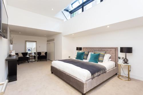 a bedroom with a large bed with blue pillows at Urban Chic - Chiltern & Baker in London