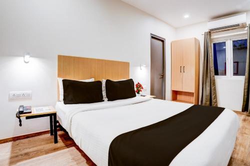 a bedroom with a large bed in a room at Super Townhouse Ulsoor Near Halasuru Metro Station in Bengaluru