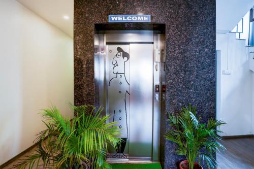 a elevator in a building with a sign that reads welcome at Super Townhouse Ulsoor Near Halasuru Metro Station in Bengaluru