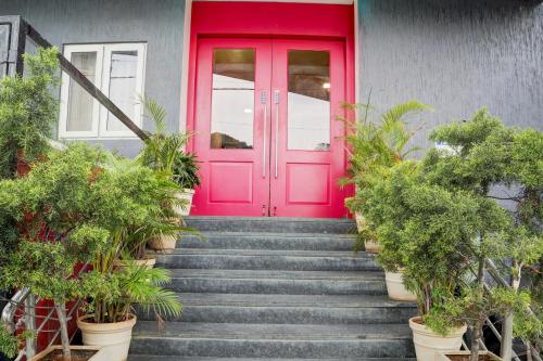 a red door on a house with stairs at Super Townhouse Ulsoor Near Halasuru Metro Station in Bengaluru