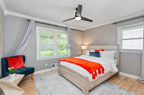 a bedroom with a bed and a chair and windows at Elegant Private Basement Apartment with Full Kitchen & Living Room in Atlanta