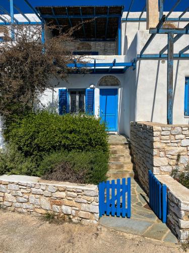 a blue fence in front of a house with blue doors at Dimitra's House in Aspro Chorio Paros