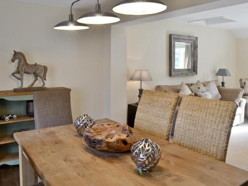 une salle à manger avec une table sur laquelle est posée une statue de cheval dans l'établissement Willow Tree Cottage, à Foxholes