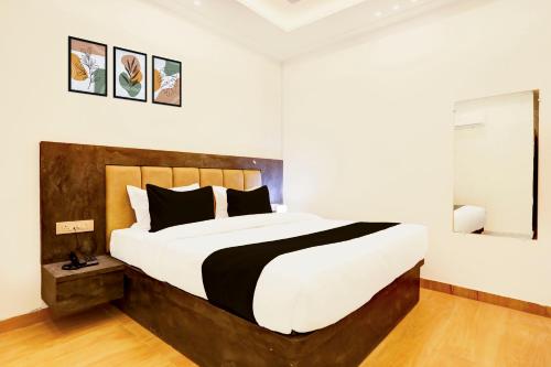 a bedroom with a large bed with white and black pillows at Super Townhouse Balua Road Pahadiya in Varanasi