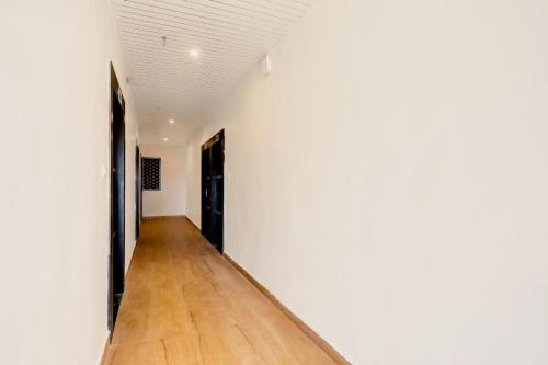 an empty hallway with white walls and wooden floors at Super Townhouse Balua Road Pahadiya in Varanasi