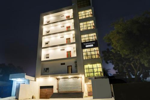 a tall building at night with its lights on at Super Townhouse Balua Road Pahadiya in Varanasi