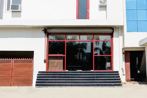 a building with a red door and stairs in front of it at Super Townhouse Balua Road Pahadiya in Varanasi