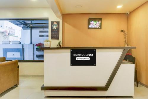 a lobby with a counter with a sign on it at Super Townhouse Oak Viman Nagar formerly Kuber Inn in Pune