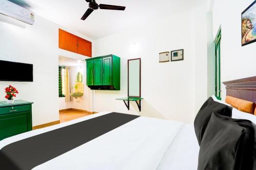 a bedroom with a bed and green cabinets at Super Hotel O Vennala Near Palarivattom in Ernakulam