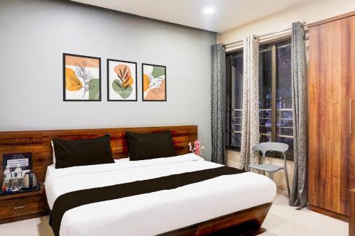 a bedroom with a large bed and a window at Super Townhouse Oak Viman Nagar formerly Kuber Inn in Pune