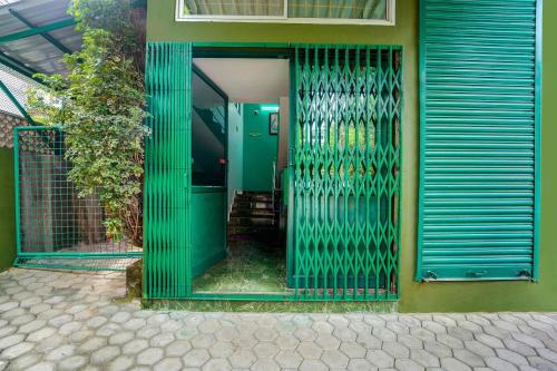 an open door of a house with a green gate at Super Hotel O Vennala Near Palarivattom in Ernakulam