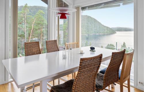 una sala da pranzo con tavolo e sedie bianchi e una grande finestra di 4 Bedroom Nice Home In Jørpeland a Jørpeland