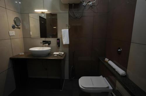 a bathroom with a sink and a toilet at Sumitel Premier Inn in Siliguri