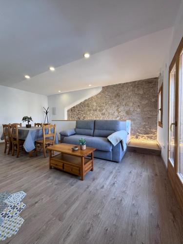 a living room with a blue couch and a table at Can Sablet in Horta de San Joan