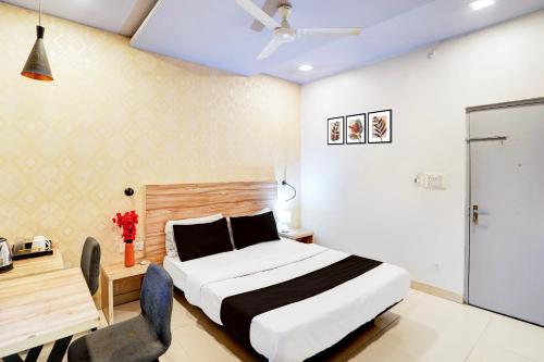 ein Schlafzimmer mit einem Bett, einem Tisch und einem Schreibtisch in der Unterkunft Super Hotel O Katol Road Friends Colony in Nagpur
