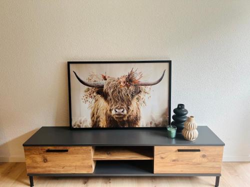 a television on a dresser with a picture of a bull at Ambiente Appartement C2 - moderne Ferienwohnung mit Terrasse in Leukerbad in Leukerbad