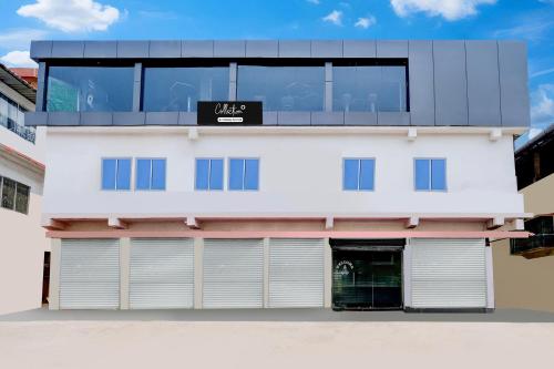 a white building with two garage doors at Collection O Ganeshguri Nayanpur Formerly Rainbow Residency in Guwahati