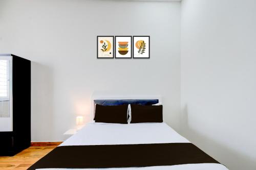a bedroom with a white bed with black and white sheets at Super Collection O BN Reddy Hyderabad in Hyderabad