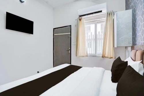 a bedroom with a white bed and a window at Super Townhouse Vasundra Nagar Formerly Joystel in Jaipur