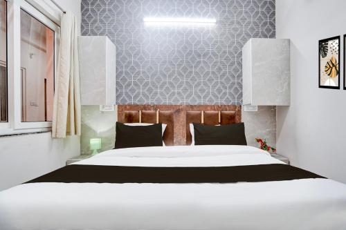 a bedroom with a large white bed in it at Super Townhouse Vasundra Nagar Formerly Joystel in Jaipur