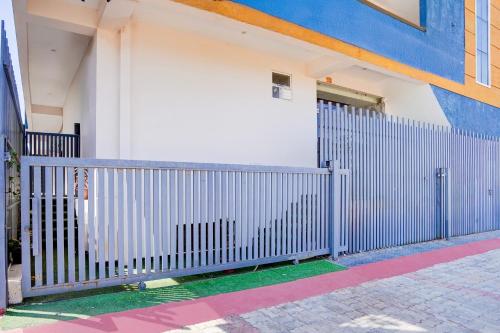a white fence in front of a building at Super Townhouse Vasundra Nagar Formerly Joystel in Jaipur