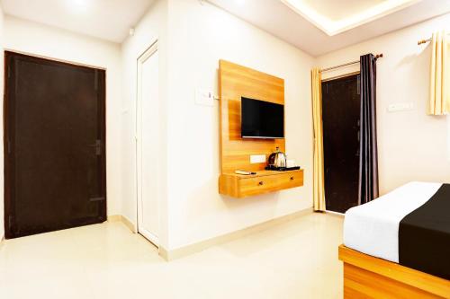 a bedroom with a bed and a television on a wall at Super Collection O Gola Road in Patna