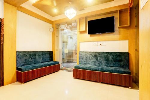 a waiting room with green seats and a flat screen tv at Super Collection O Gola Road in Patna