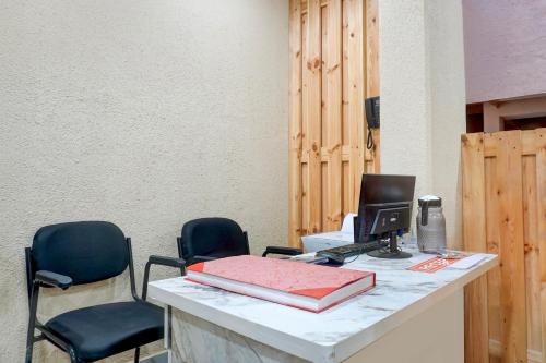 a desk with two chairs and a computer on it at Super Collection O Blue Ridge Hinjewadi in Hinjewadi
