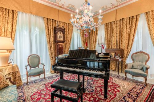 a living room with a piano and two chairs at Villa Manuela Flat in Chiesina Uzzanese