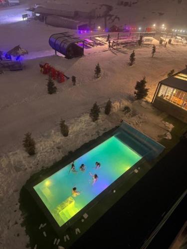 an overhead view of people swimming in a swimming pool at Atrium New Gudauri by Gudauri Travel in Gudauri