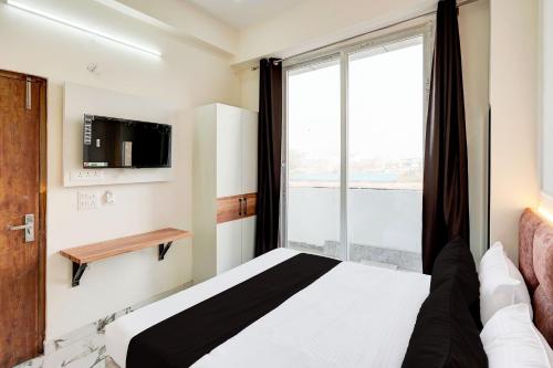 a bedroom with a bed and a large window at Super Collection O Surajpur Chowk Greater Noida in Noida
